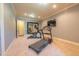 Carpeted home gym with full mirror, elliptical, and treadmill for a complete workout experience at 12317 Richmond Run Dr, Raleigh, NC 27614