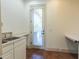 Utility room with double sink, counter space, tile flooring, and outdoor access at 12317 Richmond Run Dr, Raleigh, NC 27614