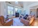 Bright living room with large windows, hardwood floors, and comfortable leather furnishings at 12317 Richmond Run Dr, Raleigh, NC 27614
