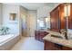 Primary bath with tub, dual vanities and granite counters at 12317 Richmond Run Dr, Raleigh, NC 27614