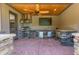 Entertain with this outdoor kitchen, featuring a stone counter, built-in grill, beverage cooler, and a ceiling fan at 12317 Richmond Run Dr, Raleigh, NC 27614