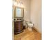 Elegant powder room features a wood vanity, framed mirror, and wood flooring at 12317 Richmond Run Dr, Raleigh, NC 27614