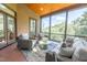 Relaxing sunroom with screened windows and comfortable seating arrangements overlooking a wooded landscape at 12317 Richmond Run Dr, Raleigh, NC 27614