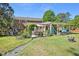 Spacious backyard with a brick home, garden, covered patio, and inviting outdoor seating area at 1315 Brigham Rd, Chapel Hill, NC 27517