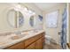 Bright bathroom featuring a vanity with double sinks, oak cabinets, and matching wall mirrors at 1315 Brigham Rd, Chapel Hill, NC 27517