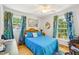 This bedroom features a ceiling fan, wood floors, windows and custom curtains at 1315 Brigham Rd, Chapel Hill, NC 27517