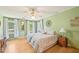 Bright bedroom with hardwood floors, windows with white curtains, and a ceiling fan at 1315 Brigham Rd, Chapel Hill, NC 27517