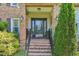 Brick stairway leading up to the front door with decorative glass and mature landscaping at 1315 Brigham Rd, Chapel Hill, NC 27517