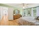Bright bedroom with wood floors, light green walls, and large windows with lots of natural light at 1315 Brigham Rd, Chapel Hill, NC 27517