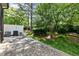 Manicured backyard with brick patio, mature trees, and white fence at 140 Sunstone Dr, Cary, NC 27519
