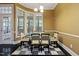 Bright dining room with a glass table, six chairs, bay window, and dark hardwood floors at 140 Sunstone Dr, Cary, NC 27519