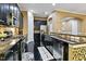Well-lit kitchen featuring stainless appliances, black cabinets, granite countertops, and dark hardwood flooring at 140 Sunstone Dr, Cary, NC 27519