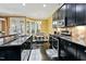 Open concept kitchen with black appliances, hardwood floors, dining area, and granite countertops at 140 Sunstone Dr, Cary, NC 27519