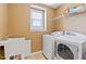 Laundry room features white washer and dryer units next to utility sink and window at 140 Sunstone Dr, Cary, NC 27519