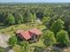 Aerial view of a wooded property featuring a home with a red roof, a pool, and a pond at 1656 Nc-42 Hwy, Moncure, NC 27559