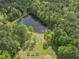 Aerial view of pond surrounded by mature trees with a lawn and garden near by at 1656 Nc-42 Hwy, Moncure, NC 27559