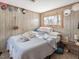 Simple bedroom with wood-paneled walls, comfortable bed, and a side table with lamp at 1656 Nc-42 Hwy, Moncure, NC 27559