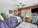 Bedroom with wood walls, ceiling fan, and bright curtains at 1656 Nc-42 Hwy, Moncure, NC 27559
