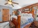 Rustic bedroom showcasing a wooden bed frame, wood walls, and ample natural light at 1656 Nc-42 Hwy, Moncure, NC 27559