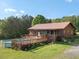 Exterior view showcasing the home's back deck with pool, screened in porch, beautiful yard and wooded landscape at 1656 Nc-42 Hwy, Moncure, NC 27559