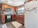 Functional kitchen with wood cabinets, black appliances, and a cozy window view at 1656 Nc-42 Hwy, Moncure, NC 27559