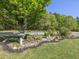 Charming landscaped garden with bird bath, lush greenery, decorative stones, and mature trees adding natural beauty at 1656 Nc-42 Hwy, Moncure, NC 27559