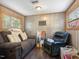 Comfortable living room with wood-paneled walls, a sofa, recliner, and natural light from the windows at 1656 Nc-42 Hwy, Moncure, NC 27559