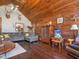 Cozy living room featuring wood walls, comfortable seating, and hardwood floors at 1656 Nc-42 Hwy, Moncure, NC 27559