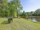 Peaceful pond-side retreat with seating, ideal for relaxation and enjoying nature at 1656 Nc-42 Hwy, Moncure, NC 27559