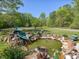 Scenic backyard pond with a fountain, surrounded by decorative rocks, lush plants, and greenery at 1656 Nc-42 Hwy, Moncure, NC 27559