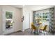 Bright dining area with glass table, four chairs, view to the outdoor living and accent curtains at 168 Holmes Corner Dr, Smithfield, NC 27577