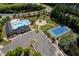Aerial view of the community amenities including a pool, tennis court, playground, parking area, and surrounding greenery at 1719 Willowcrest Rd, Durham, NC 27703