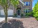 Inviting front entrance with stone accents, a dark wood door, and neatly trimmed landscaping at 1719 Willowcrest Rd, Durham, NC 27703