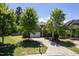 Charming two-story brick home with lush green trees, grass, and a driveway leading to an attached garage at 1719 Willowcrest Rd, Durham, NC 27703
