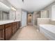 Main bathroom featuring double vanity, large mirrors, soaking tub and glass shower at 1719 Willowcrest Rd, Durham, NC 27703