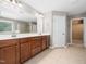 Spacious main bathroom with double sinks, large mirror, tiled floor and a walk-in closet at 1719 Willowcrest Rd, Durham, NC 27703