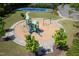 A view of the community playground featuring mature trees, a green play structure, swings and a park bench at 1719 Willowcrest Rd, Durham, NC 27703