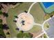 A charming playground is showcased from an overhead perspective, surrounded by greenery and concrete walkways at 1719 Willowcrest Rd, Durham, NC 27703