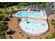 Aerial view of the splash pad and pool with tables, chairs, and umbrellas at 1719 Willowcrest Rd, Durham, NC 27703