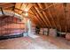 A large unfinished attic space with exposed wood beams and insulation, offering ample storage at 1904 Victoria Rd, Raleigh, NC 27608