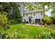 Picturesque backyard with a manicured lawn, lush garden beds, and a charming view of the home's exterior at 1904 Victoria Rd, Raleigh, NC 27608