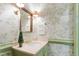 Charming powder room featuring floral wallpaper, elegant fixtures, and a marble countertop at 1904 Victoria Rd, Raleigh, NC 27608