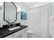 Bathroom with large vanity, shower, and patterned shower curtain at 1904 Victoria Rd, Raleigh, NC 27608