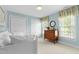 Charming bedroom with blue walls, white trim, two windows, and a white bed at 1904 Victoria Rd, Raleigh, NC 27608