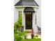 Charming entryway with a black door and awning, complemented by lush greenery and a cozy patio area at 1904 Victoria Rd, Raleigh, NC 27608