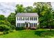 Charming two-story home with black shutters, surrounded by lush greenery and a well-manicured lawn at 1904 Victoria Rd, Raleigh, NC 27608