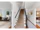 Inviting foyer featuring a carpeted staircase with dark railing and glimpses into adjacent living spaces at 1904 Victoria Rd, Raleigh, NC 27608