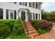 Close-up of home's entrance featuring brick steps, black railings, and meticulously maintained landscaping at 1904 Victoria Rd, Raleigh, NC 27608