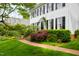 Charming home with brick walkway, lush landscaping, mature trees, and a well-maintained green lawn at 1904 Victoria Rd, Raleigh, NC 27608