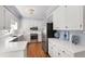 Bright kitchen featuring white cabinetry, stainless steel appliances, and hardwood floors at 1904 Victoria Rd, Raleigh, NC 27608